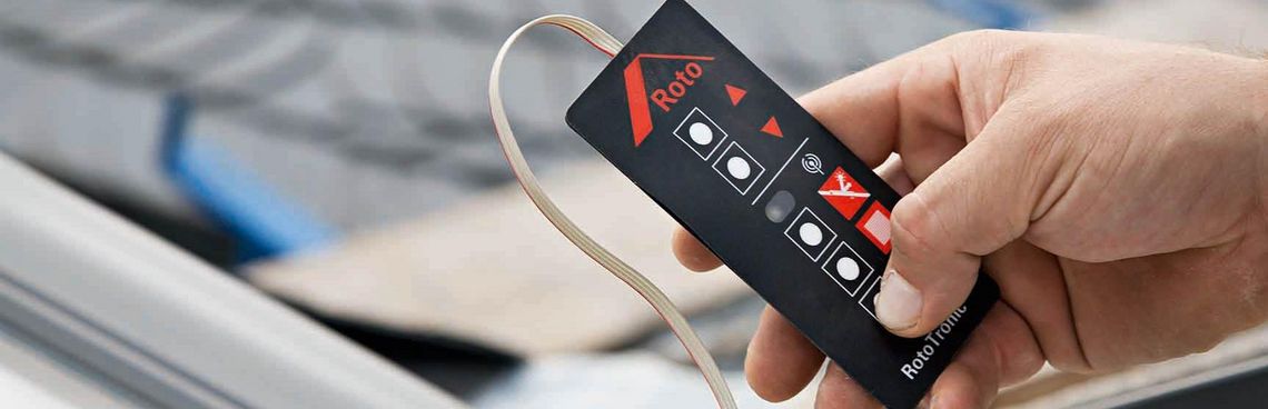 Eine Hand lernt auf einer Fernbedienung eines RotoTronic Fensters einen Kanal ein